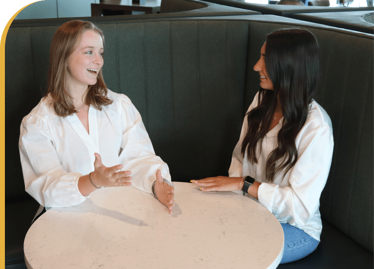 Two Marketing Interns Engaged in a Discussion