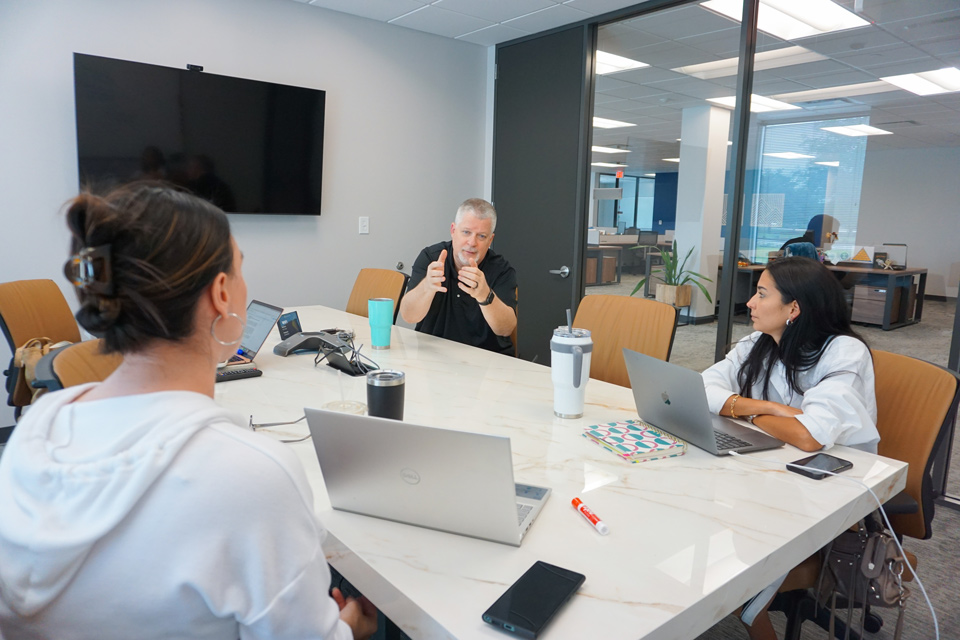 A marketing agency team in Houston conducting a client interview in a modern office setting