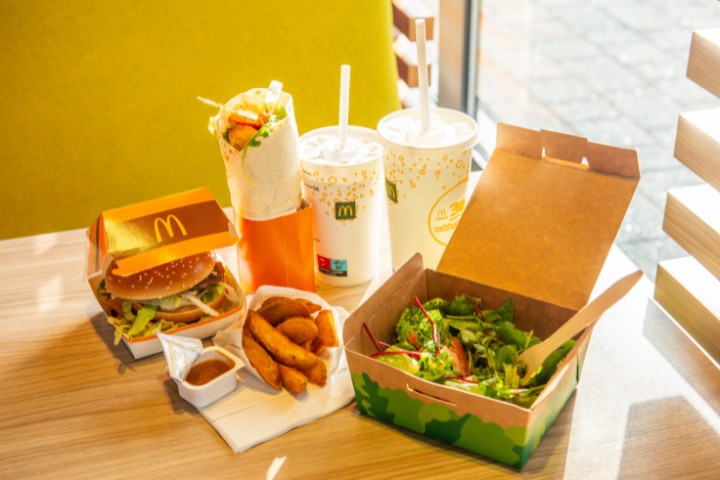 A variety of McDonald's menu items, including a burger, wrap, salad, fries, and drinks