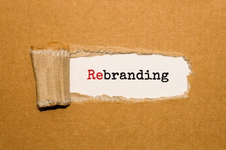 Rebranding text shown under ripped paper symbolizing brand transformation