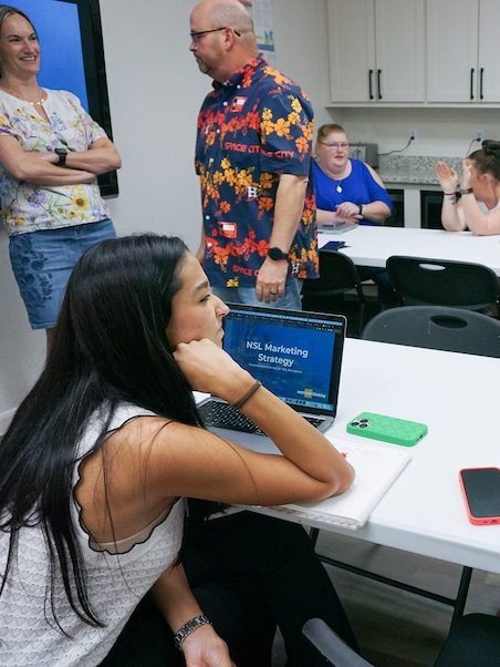 Marketing strategy workshop with a consultant reviewing campaign ideas on a laptop